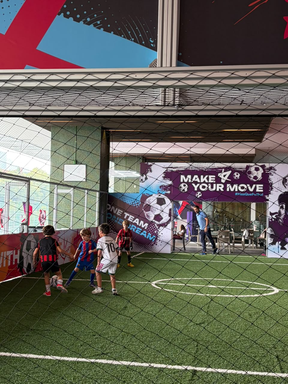 Niños jugando un partido en la cancha interior de Kick Zone